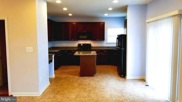 a kitchen with stainless steel appliances granite countertop a refrigerator a sink and a microwave