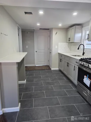 a kitchen with a sink a counter space and cabinets