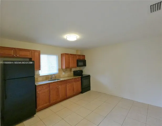 a kitchen with granite countertop a refrigerator and a sink