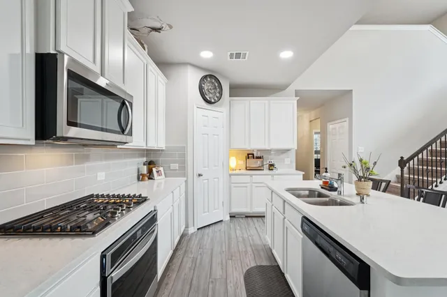 a kitchen with a sink stove top oven and microwave