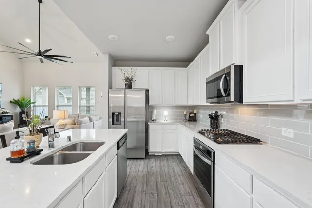 a kitchen that has a sink cabinets and stainless steel appliances