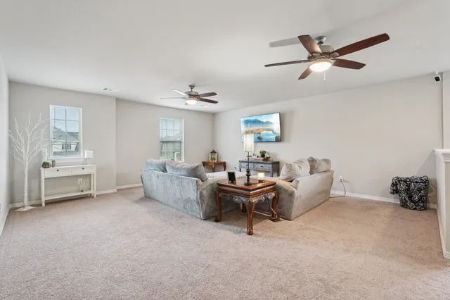 a living room with furniture and a ceiling fan
