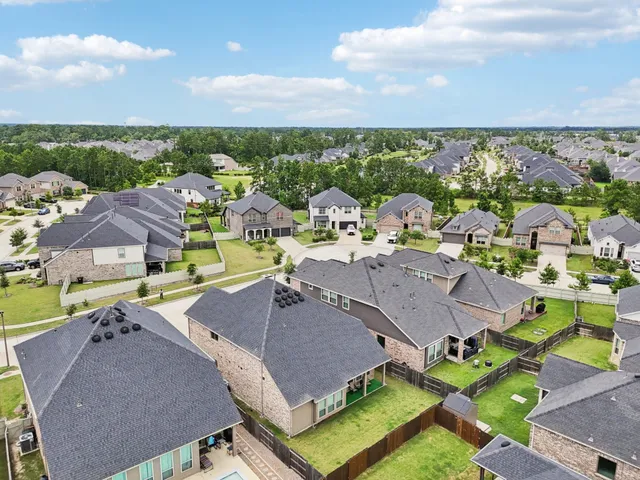 an aerial view of residential houses with outdoor space and swimming pool