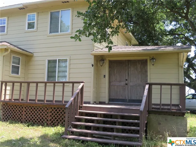 a view of a house with a large window stairs and a wooden floor