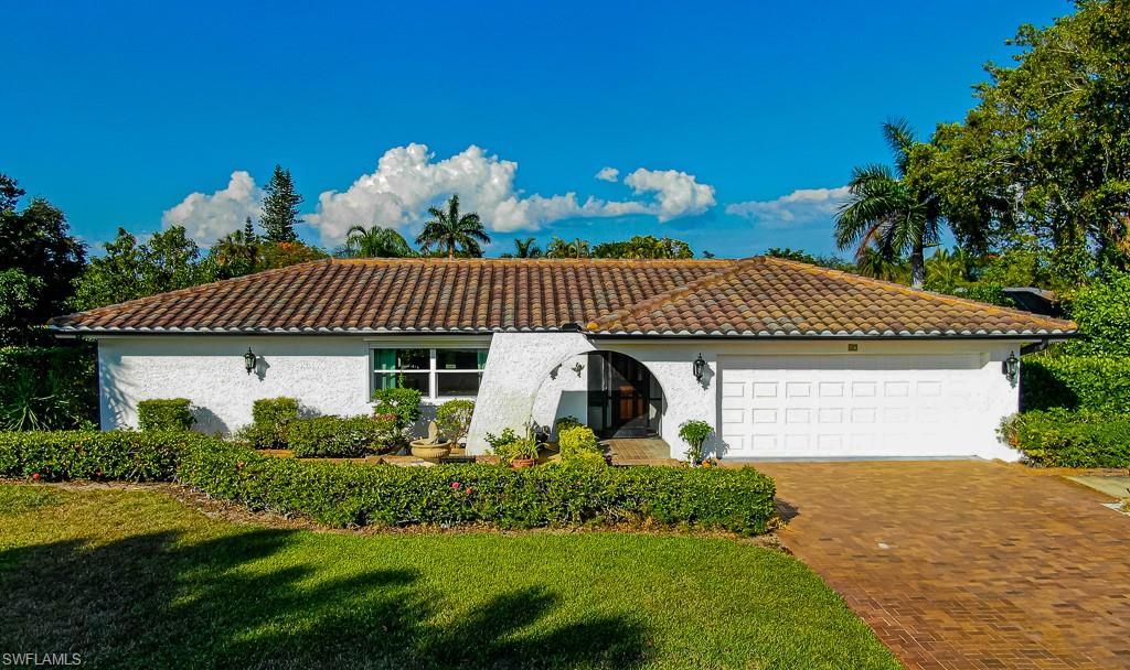 Mediterranean / spanish-style home with an attached garage, stucco siding, decorative driveway, and a tiled roof