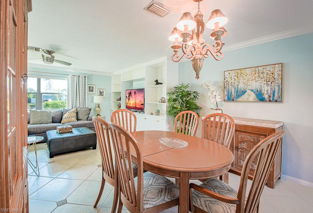 67 Pebble Beach Boulevard Naples, FL 34113 - Photo 14 of 28 Dining space featuring baseboards, light tile patterned flooring, visible vents, and crown molding