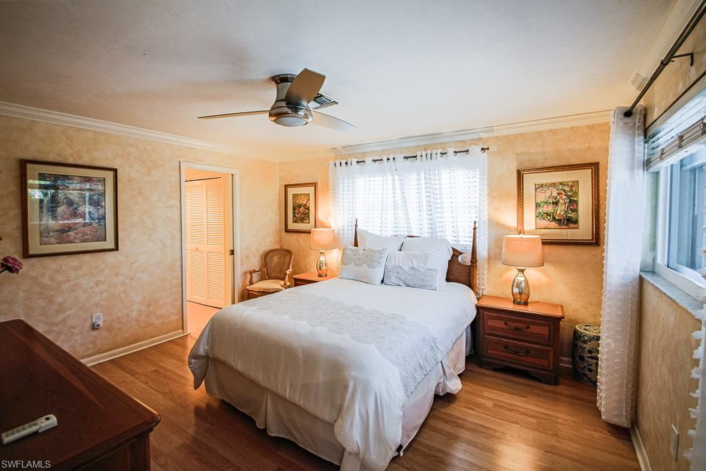 67 Pebble Beach Boulevard Naples, FL 34113 - Photo 16 of 28 Bedroom with baseboards, ceiling fan, wood finished floors, crown molding, and a closet