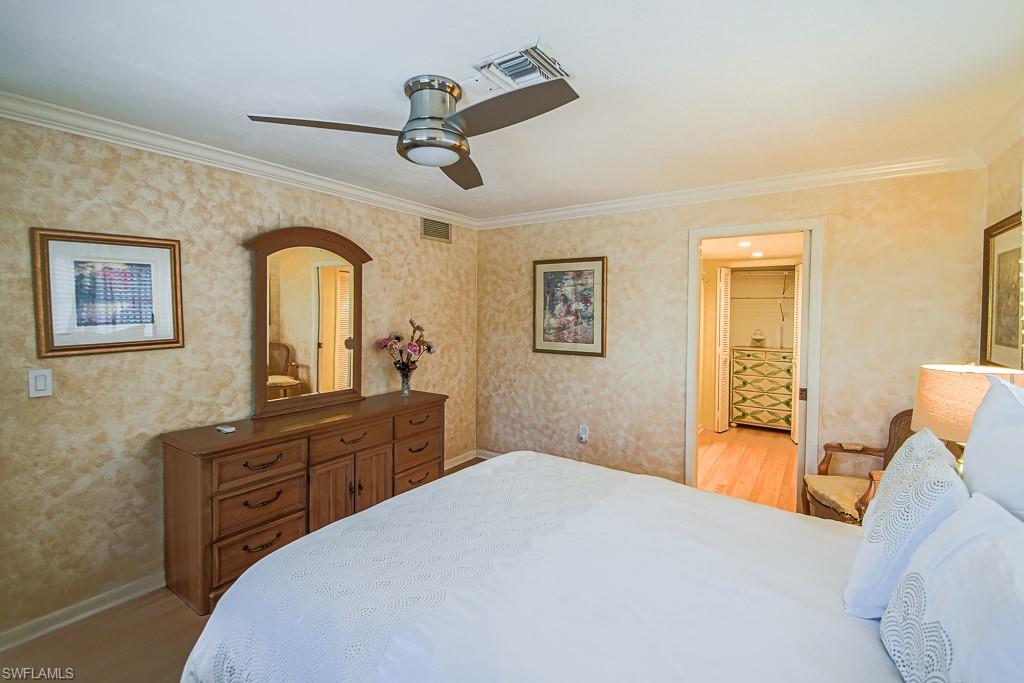 67 Pebble Beach Boulevard Naples, FL 34113 - Photo 17 of 28 Bedroom featuring visible vents, ornamental molding, and light wood-style flooring