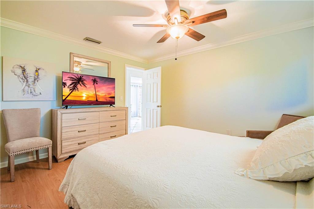 67 Pebble Beach Boulevard Naples, FL 34113 - Photo 20 of 28 Bedroom featuring ornamental molding, light wood-type flooring, visible vents, and a ceiling fan