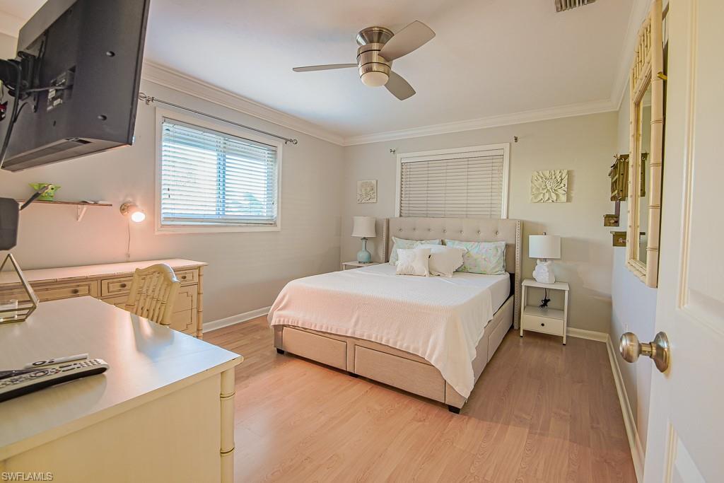 67 Pebble Beach Boulevard Naples, FL 34113 - Photo 21 of 28 Bedroom with baseboards, light wood-type flooring, visible vents, and crown molding