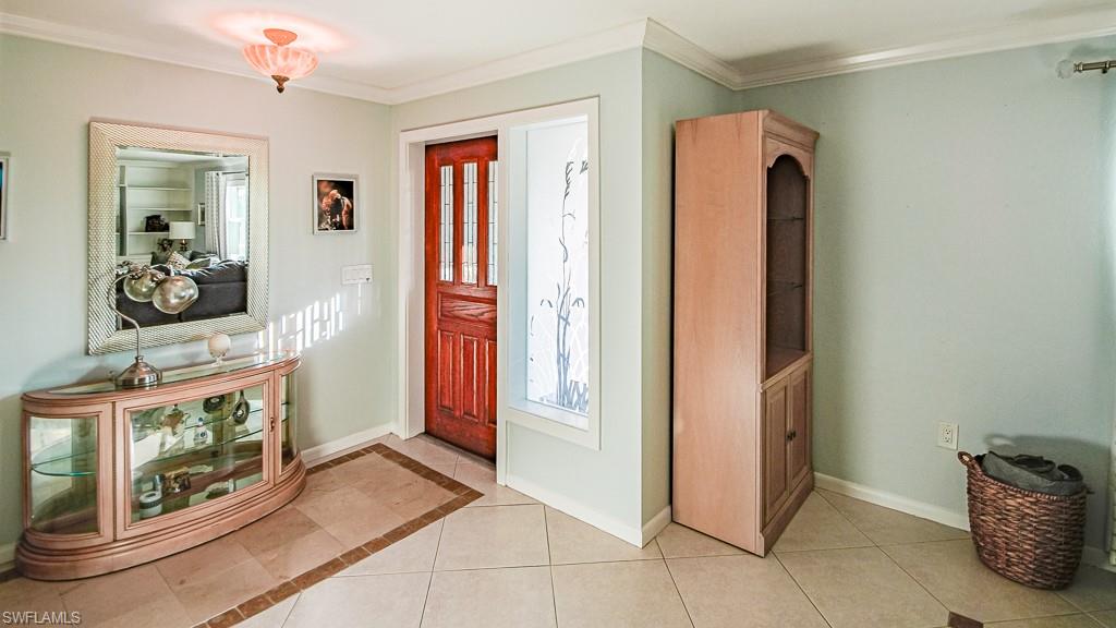 67 Pebble Beach Boulevard Naples, FL 34113 - Photo 8 of 28 Foyer featuring light tile patterned floors, ornamental molding, and baseboards