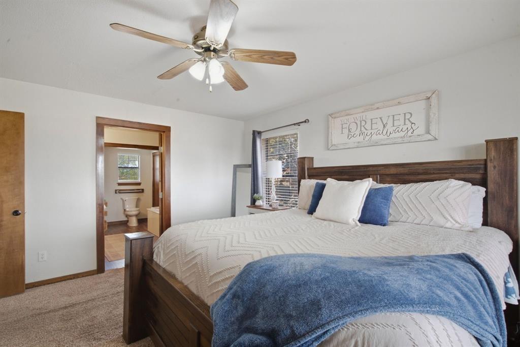 950 Johnson Bend Road Weatherford, TX 76088 - Photo 19 of 40 Carpeted bedroom with a wood-finish ceiling fan and light fixture