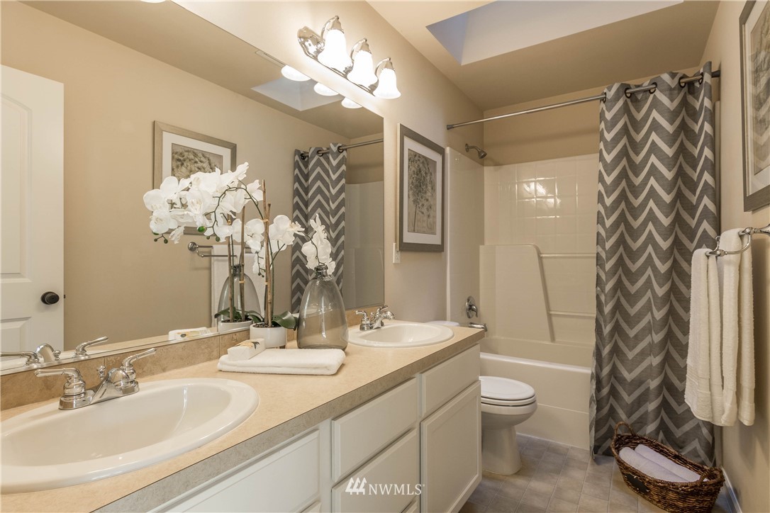 4207 223rd Place Southeast Bothell, WA 98021 - Photo 14 of 21 a bathroom with a granite countertop sink a toilet and a mirror