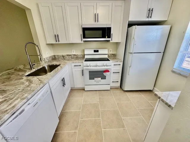 a kitchen with a sink a stove and cabinets