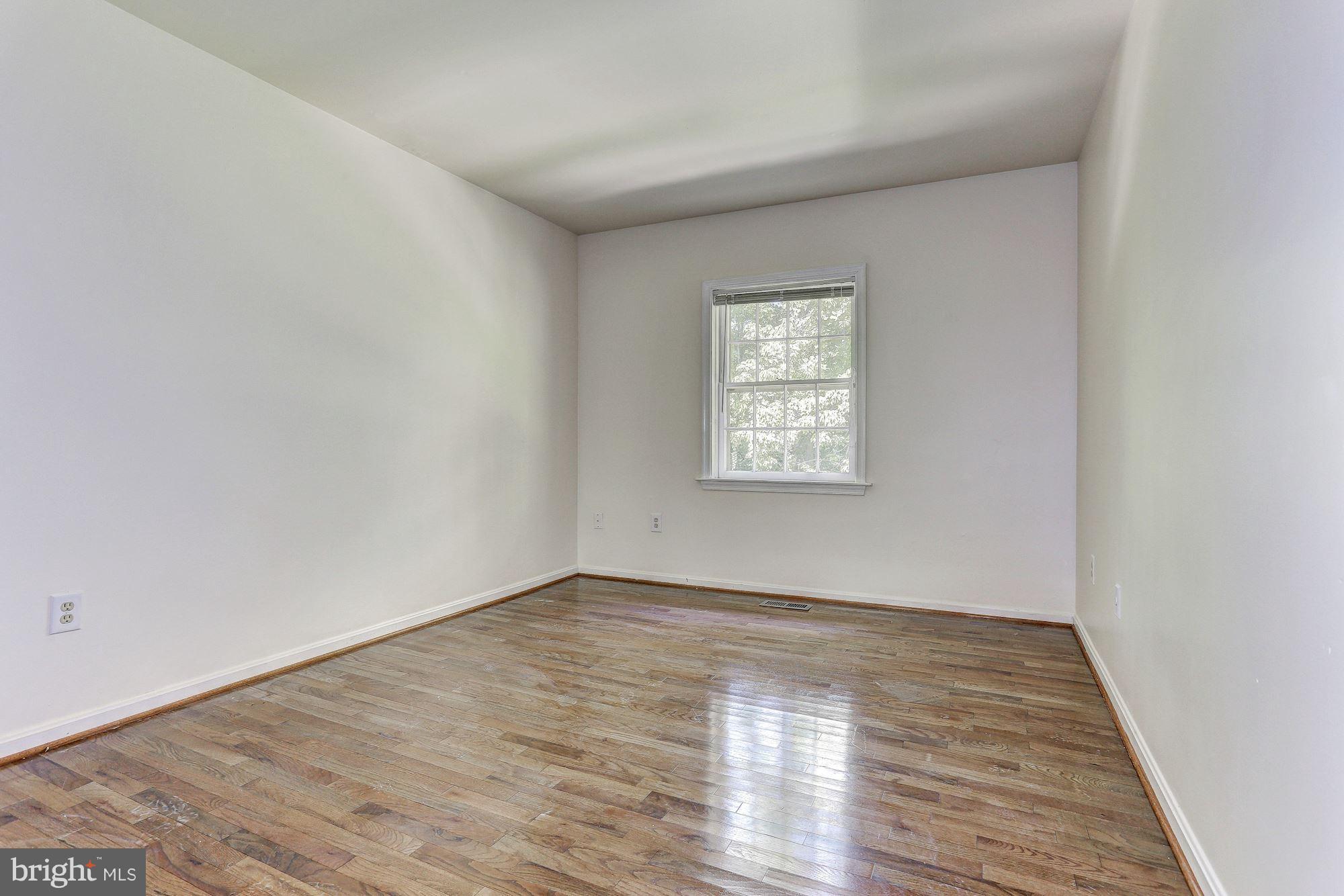 9776 Whiskey Run Laurel, MD 20723 - Photo 9 of 15 a view of an empty room with wooden floor and a window