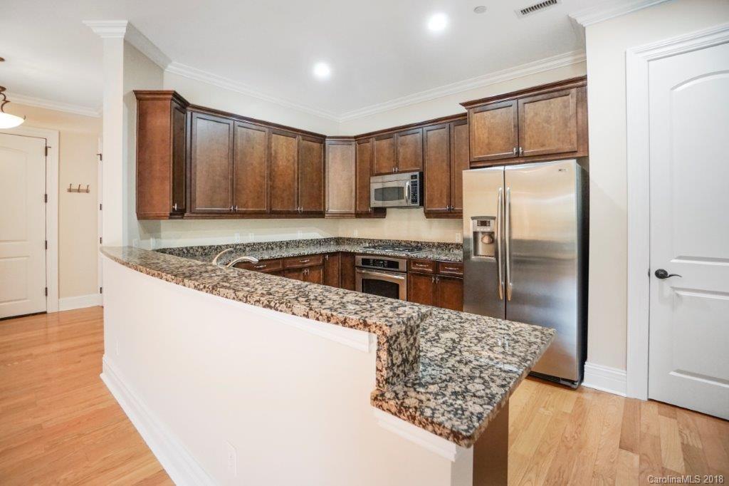 3272 Park Road Charlotte, NC 28209 - Photo 13 of 31 a kitchen with stainless steel appliances granite countertop a refrigerator a stove and a wooden floors