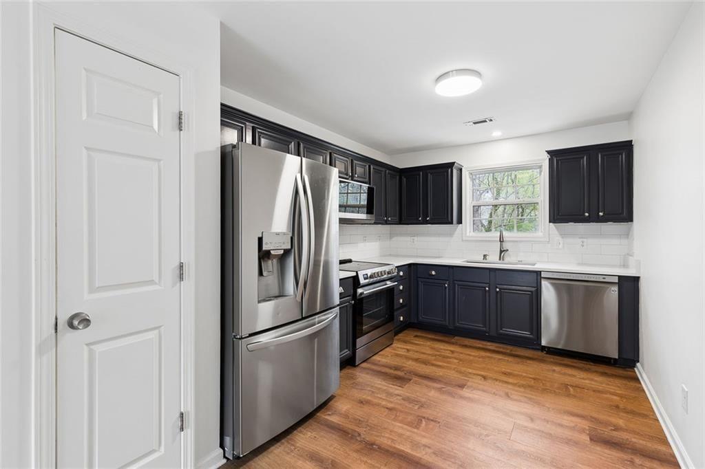 67 Johnson Road Northwest Atlanta, GA 30318 - Photo 12 of 31 a kitchen with stainless steel appliances granite countertop a refrigerator stove microwave and sink