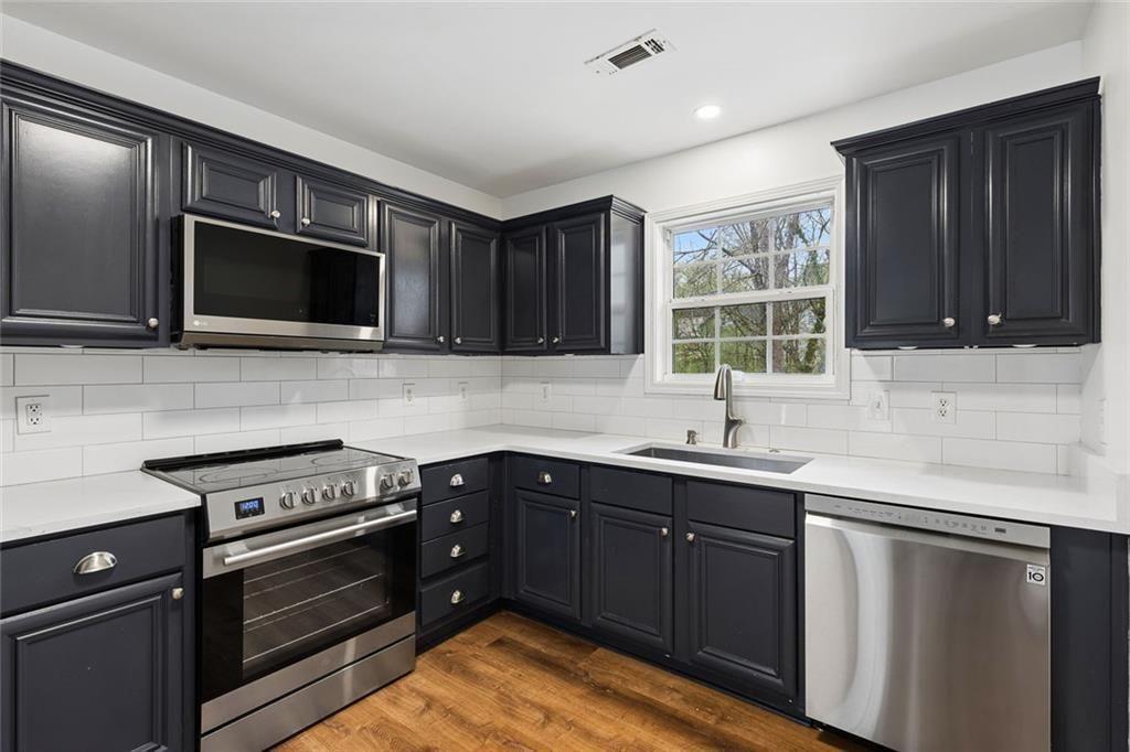 67 Johnson Road Northwest Atlanta, GA 30318 - Photo 13 of 31 a kitchen with a sink stove and microwave
