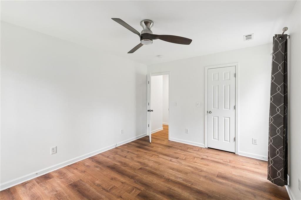 67 Johnson Road Northwest Atlanta, GA 30318 - Photo 17 of 31 a view of empty room with wooden floor and ceiling fan