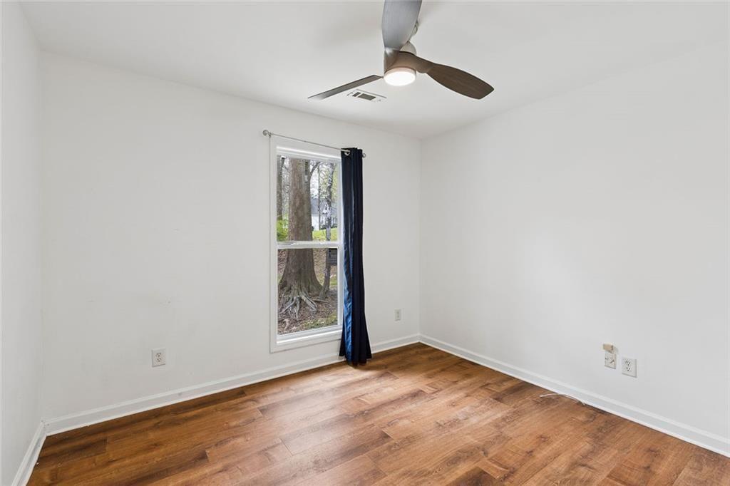 67 Johnson Road Northwest Atlanta, GA 30318 - Photo 23 of 31 an empty room with wooden floor chandelier fan and windows
