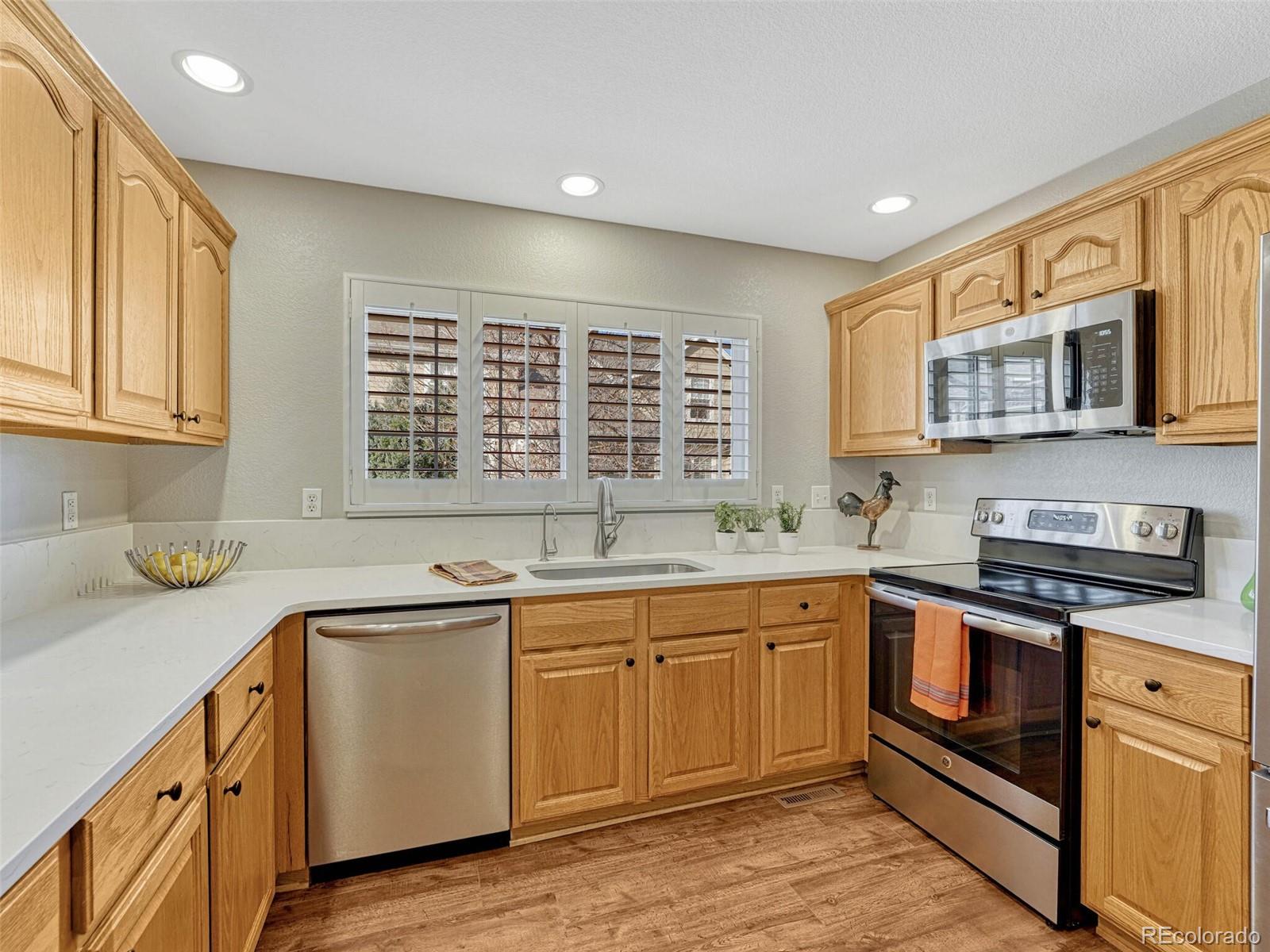 6109 Trailhead Road Highlands Ranch, CO 80130 - Photo 13 of 35 a kitchen with stainless steel appliances granite countertop a sink and cabinets
