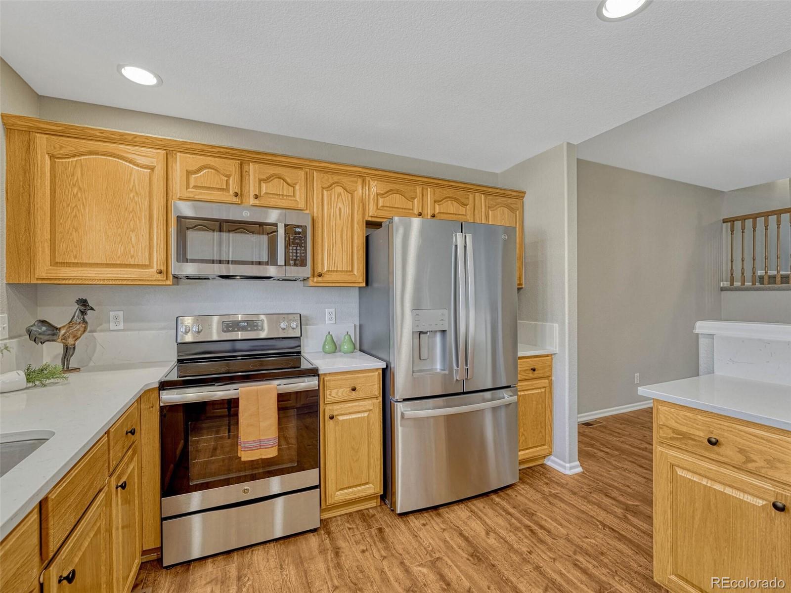 6109 Trailhead Road Highlands Ranch, CO 80130 - Photo 15 of 35 a kitchen with a refrigerator stove and wooden cabinets