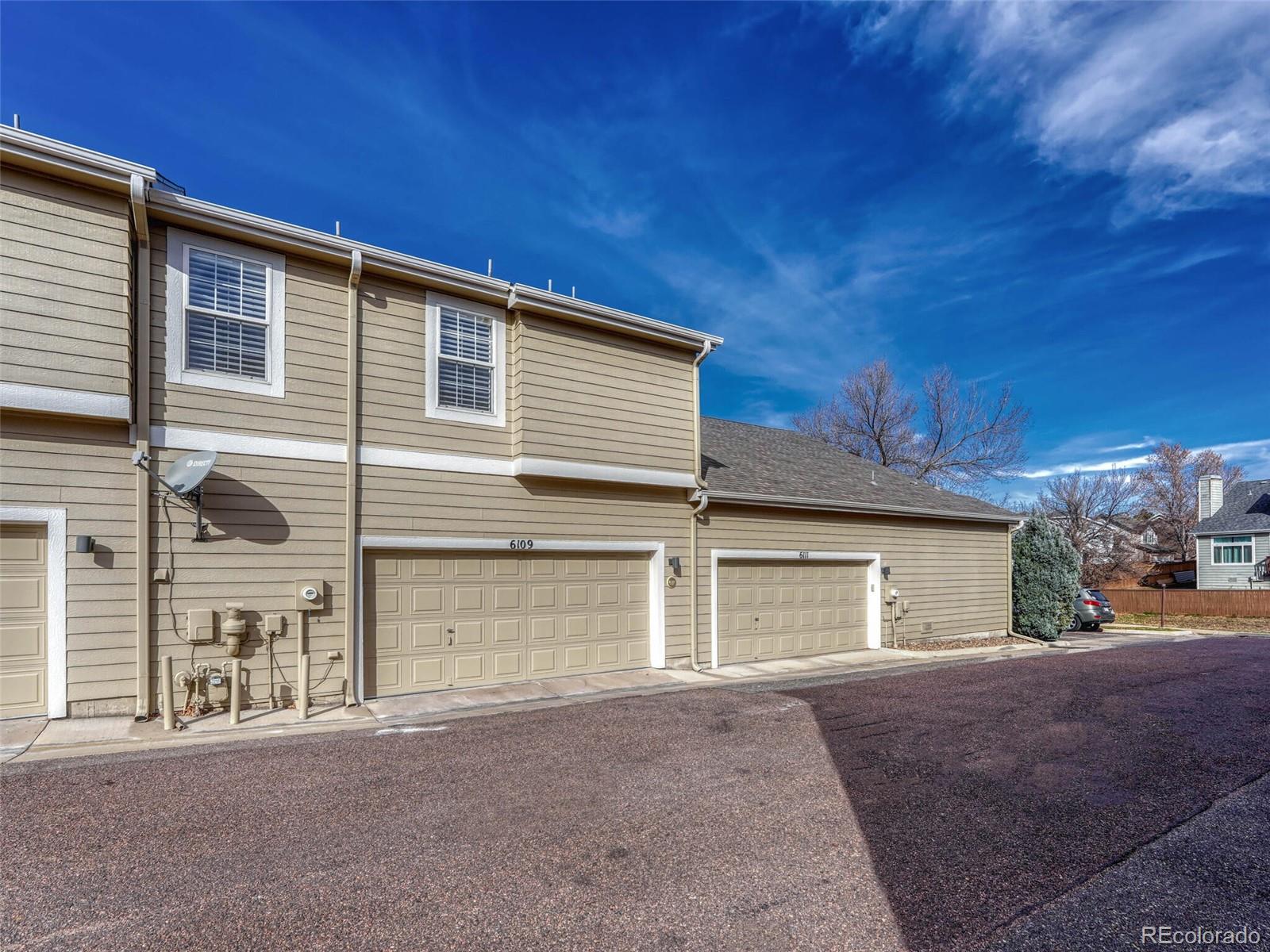 6109 Trailhead Road Highlands Ranch, CO 80130 - Photo 29 of 35 a front view of a house with a yard and garage
