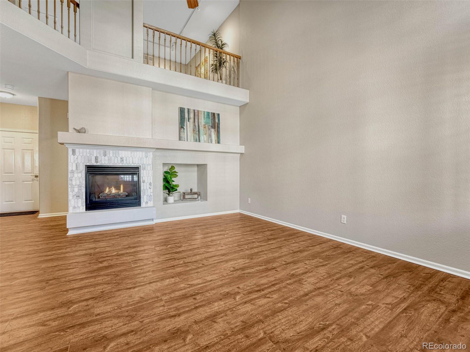 6109 Trailhead Road Highlands Ranch, CO 80130 - Photo 6 of 35 a view of an empty room with wooden floor and a window