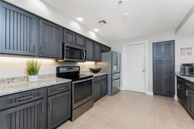 a kitchen with granite countertop wooden cabinets a stove top oven a sink and dishwasher