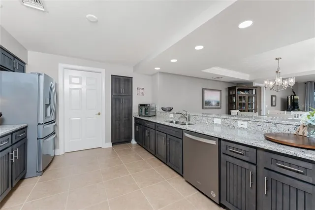 a large kitchen with stainless steel appliances granite countertop a refrigerator and a sink