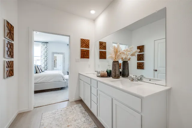 a en suite bathroom with a double vanity sink and a mirror