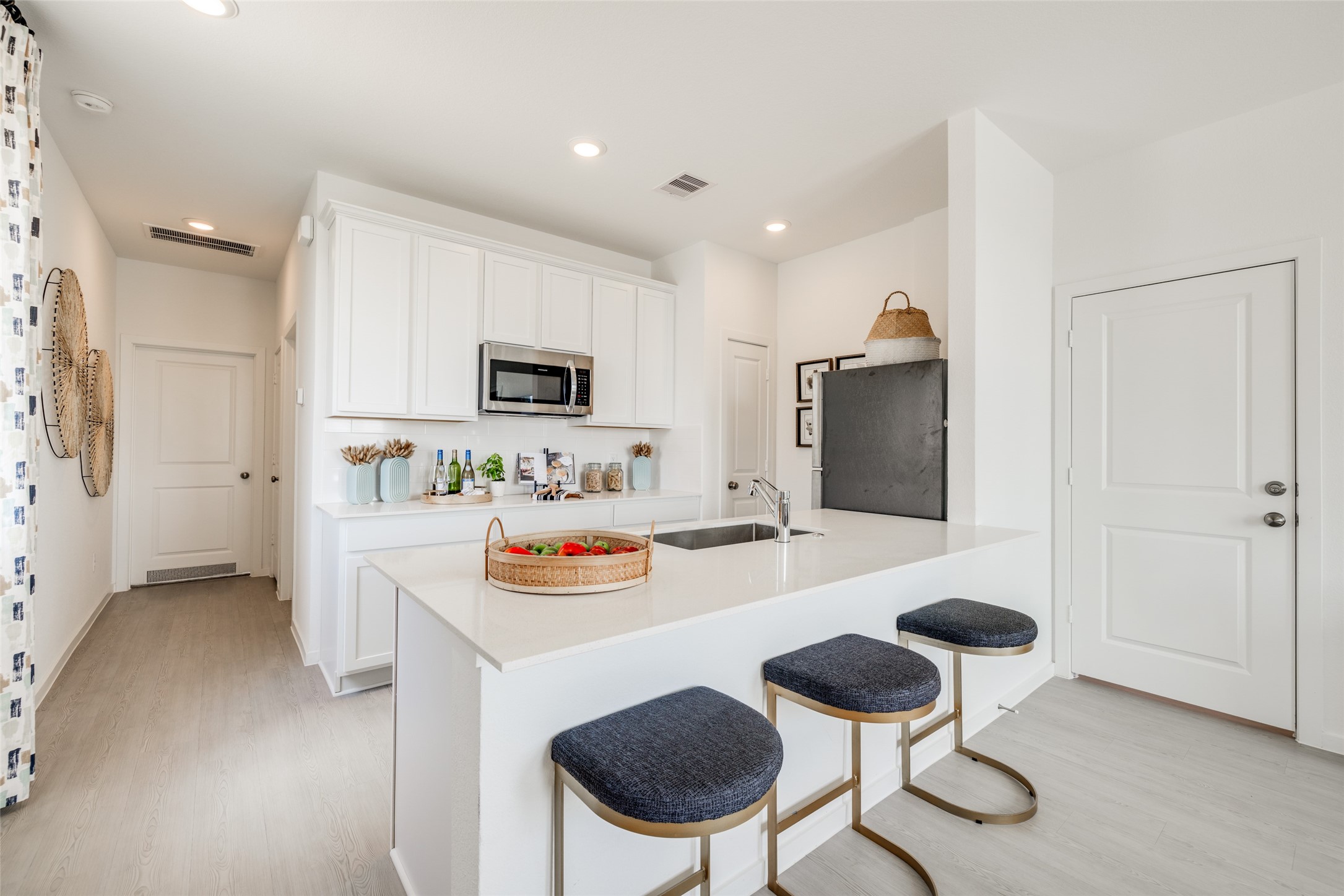 8310 Amber Summit Lane Angleton, TX 77515 - Photo 17 of 19 a kitchen with stainless steel appliances kitchen island granite countertop a sink a stove a refrigerator and white cabinets with wooden floor