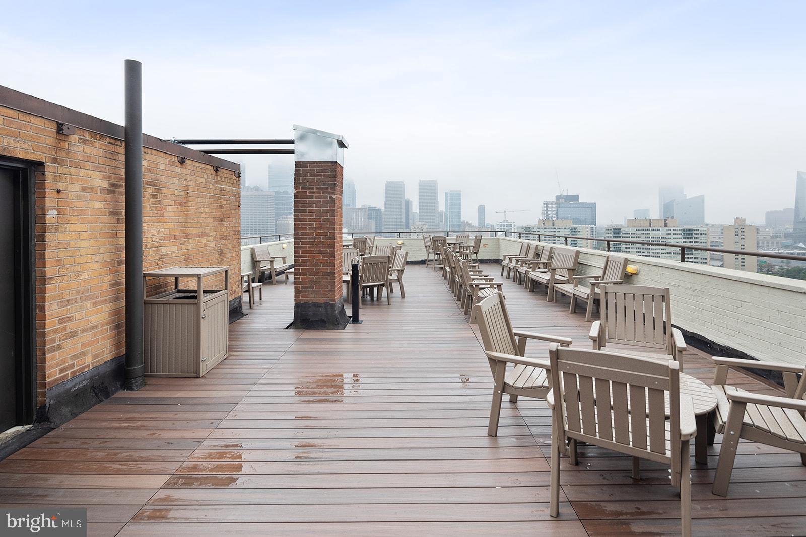 2201 Pennsylvania Avenue, Unit 1104 Philadelphia, PA 19130 - Photo 32 of 45 a view of a rooftop deck with chairs and wooden floor