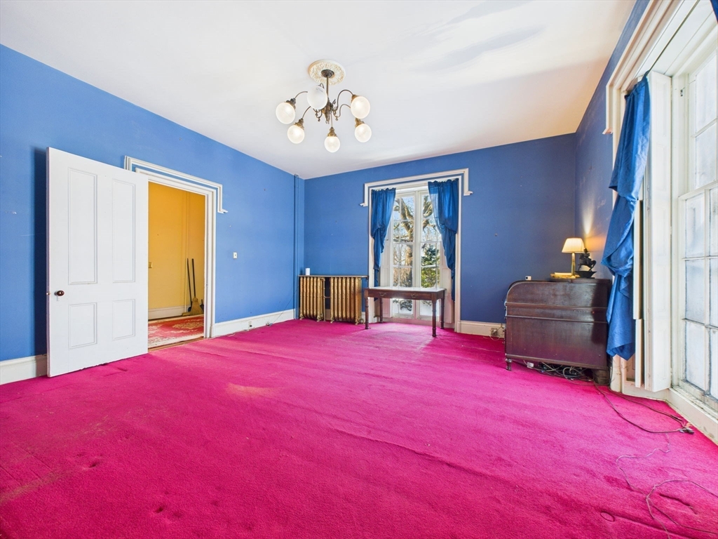 181 Washington Street Fairhaven, MA 02719 - Photo 15 of 41 a bedroom with a bed and a chandelier