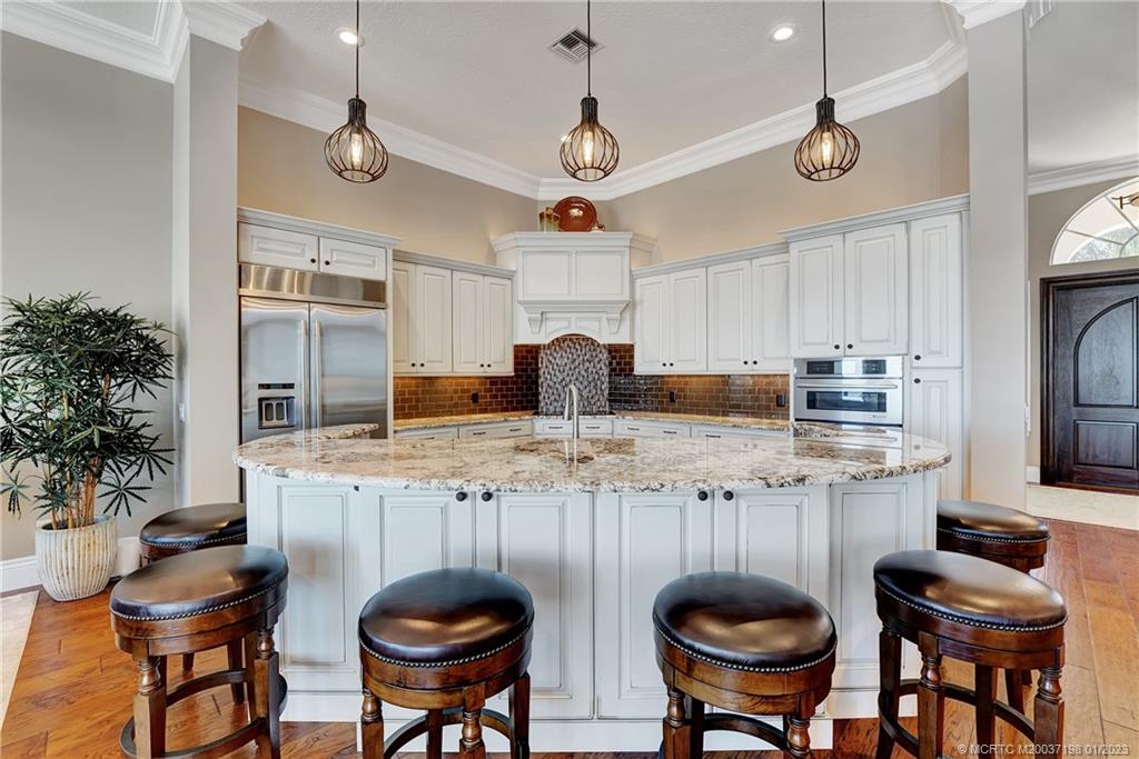 825 Southeast Riverside Drive Stuart, FL 34994 - Photo 44 of 96 a kitchen with stainless steel appliances granite countertop a table and chairs in it