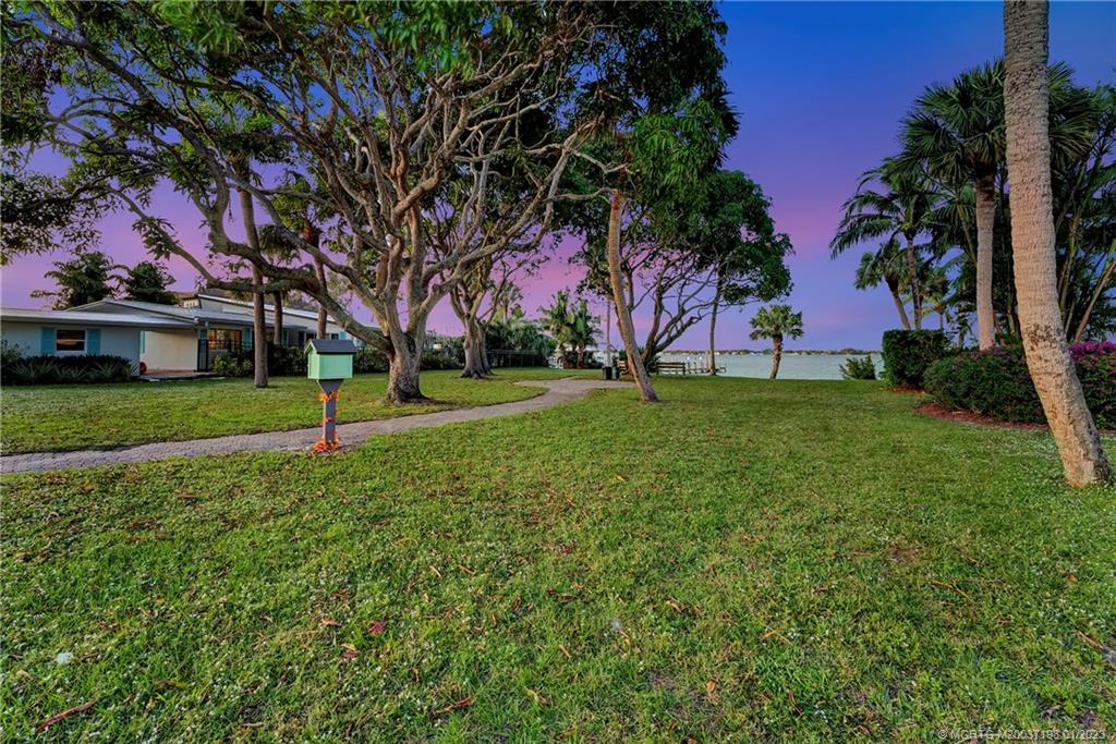 825 Southeast Riverside Drive Stuart, FL 34994 - Photo 84 of 96 a backyard of a house with lots of green space and fountain