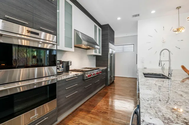 a kitchen with stainless steel appliances granite countertop a stove a sink and a microwave