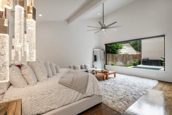 a bedroom with furniture and large windows