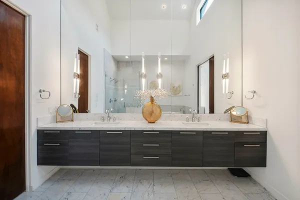 a bathroom with a granite countertop double vanity sink and a mirror
