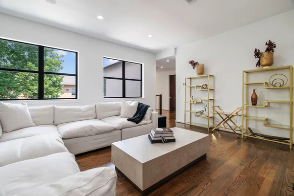 a living room with furniture a flat screen tv and a large window
