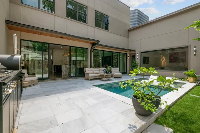 a view of a patio with table and chairs potted plants and floor to ceiling window
