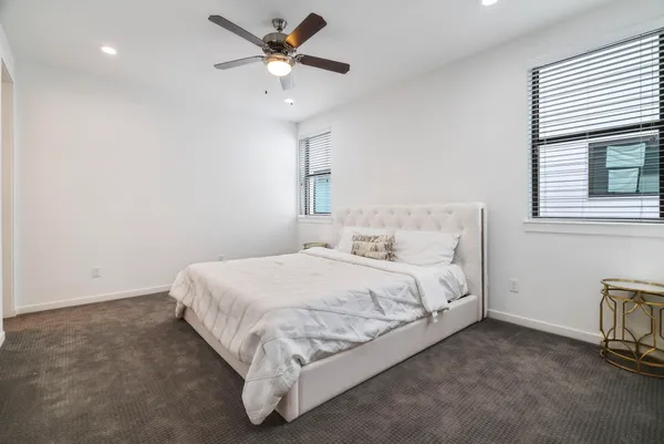a spacious bedroom with a bed and a ceiling fan