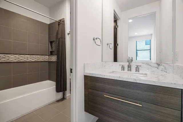a bathroom with a granite countertop sink a toilet and bathtub