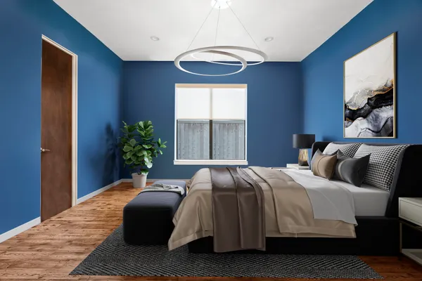a bedroom with a bed lamp and a potted plant