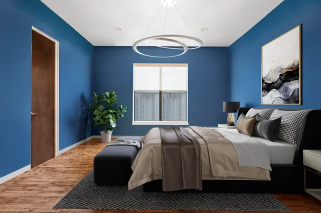 a bedroom with a bed lamp and a potted plant