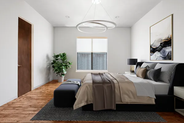 a bedroom with a bed lamp and a potted plant