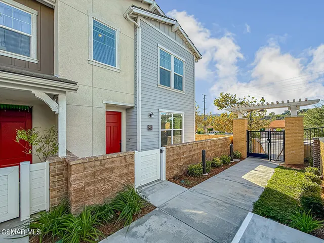 a view of a brick house with many windows next to a yard