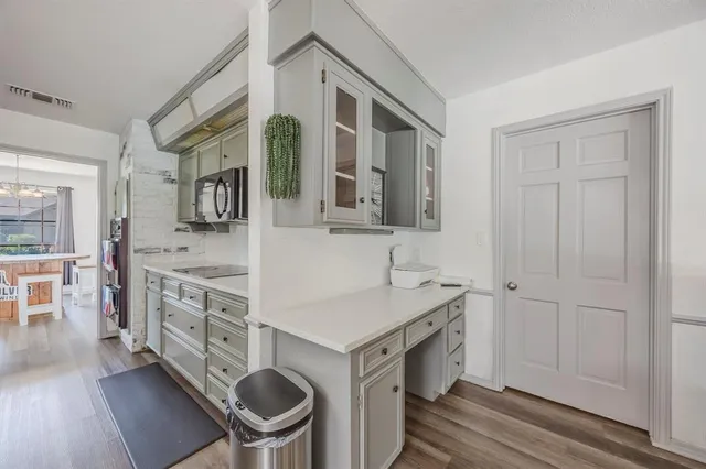a kitchen with a sink cabinets and wooden floor