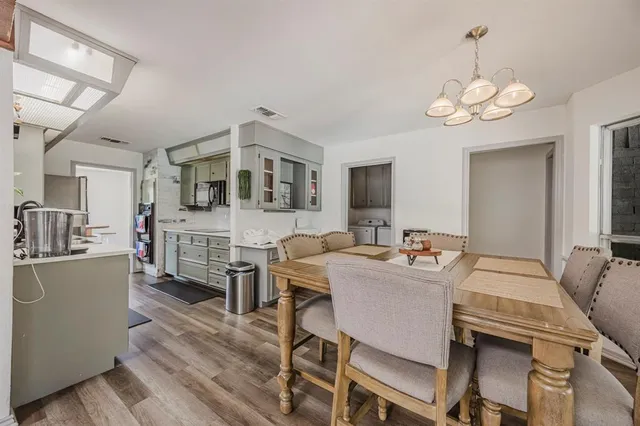 a view of a dining room with furniture a chandelier and wooden floor