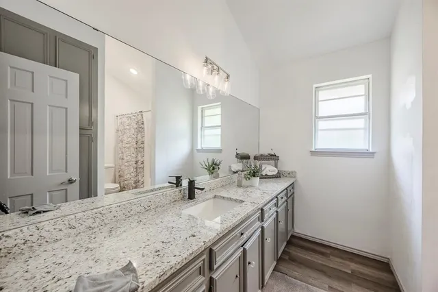 a bathroom with a granite countertop sink and a mirror